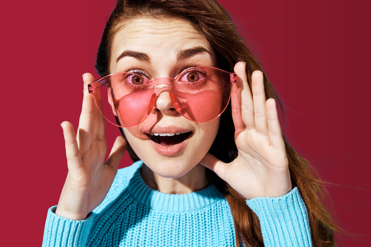 woman with pink glasses and surprised face
